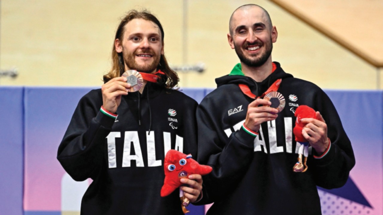 Bronze medallists Italy's Lorenzo Bernard (R) and pilot Davide Plebani celebrate on the podium of ...